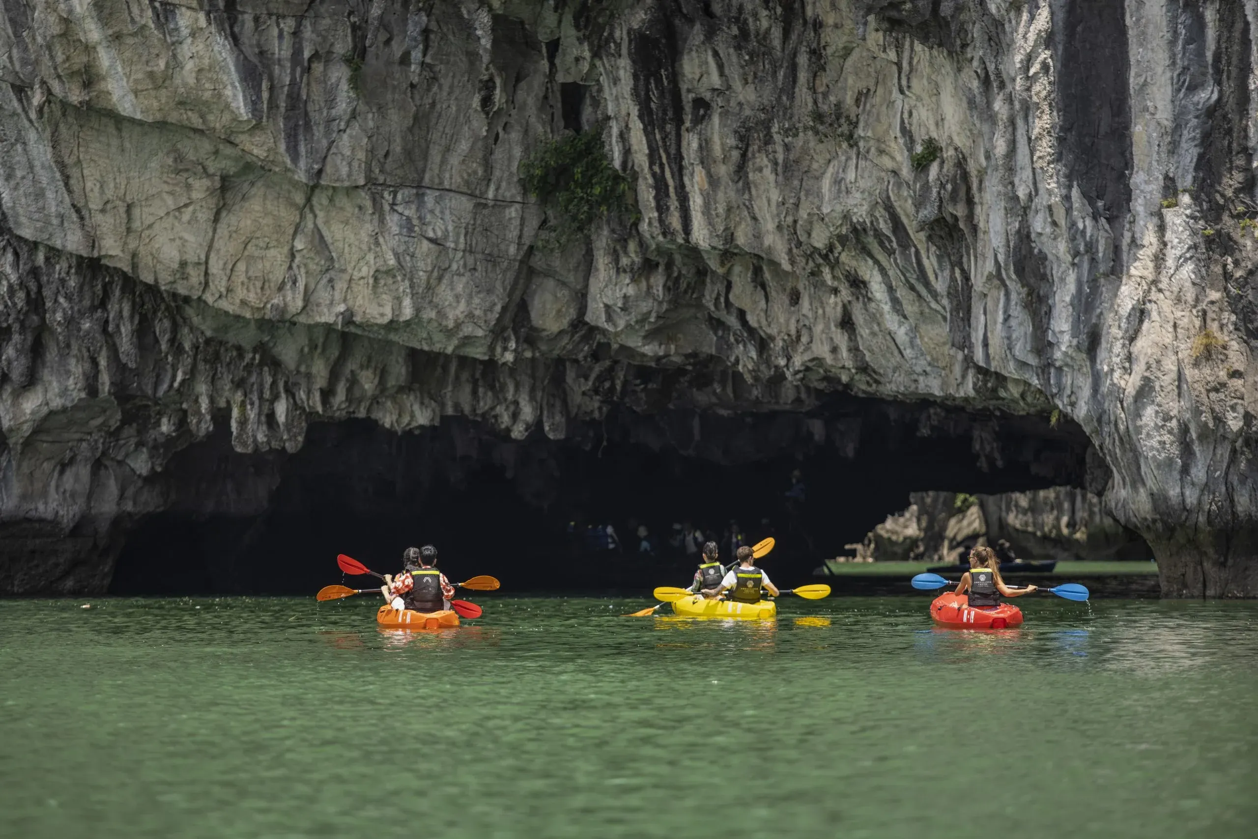 Kayaking through Luon Cave arch into hidden lagoon Ha Long Bay